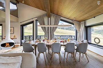 A dining room with a table and chairs and a fireplace