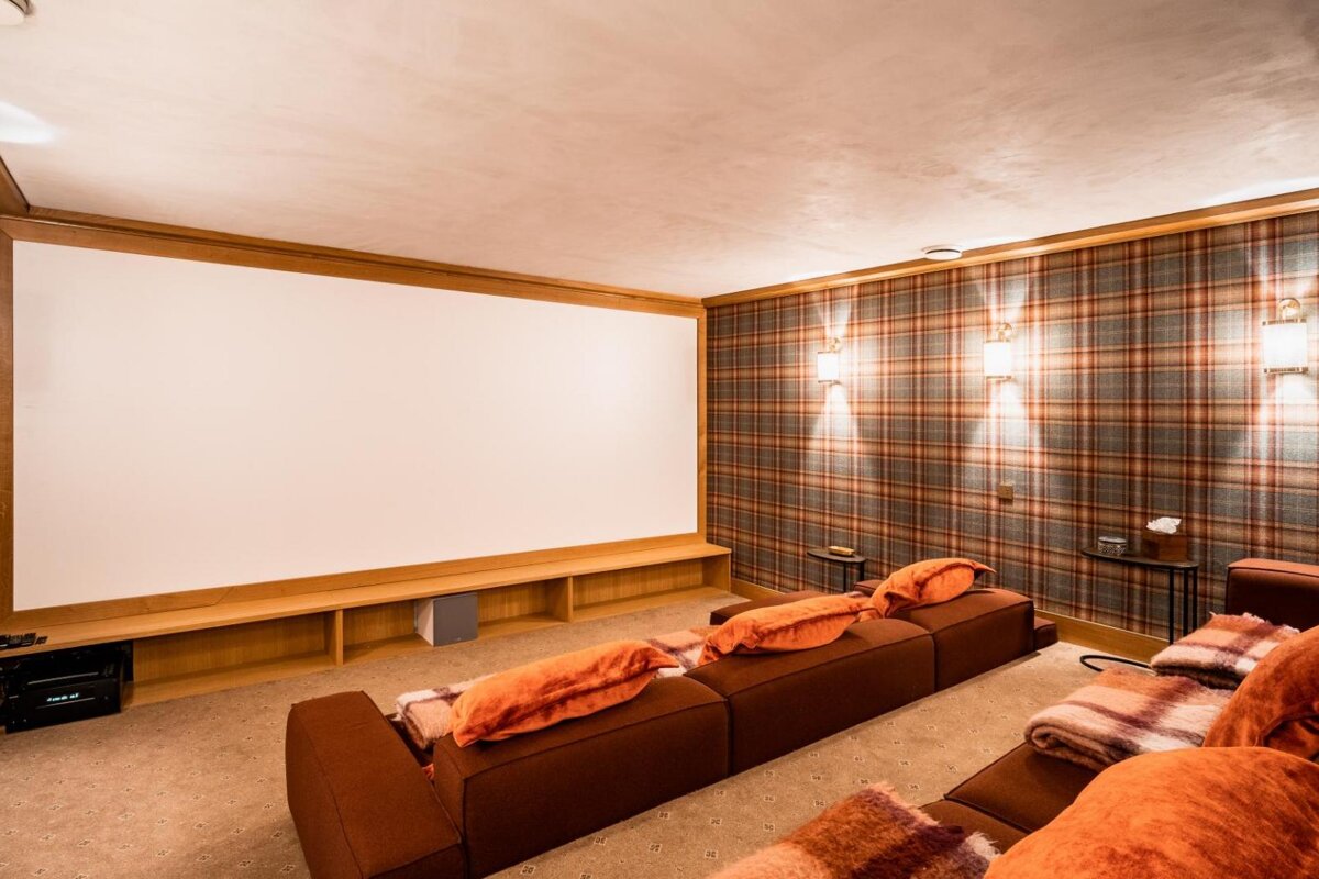 A home theater with plaid walls and a large screen