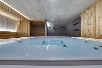 A hot tub in a room with wooden walls