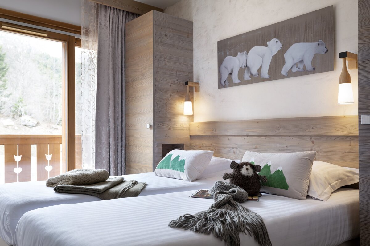A bedroom with two beds and a painting of polar bears on the wall