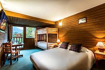 A hotel room with a bunk bed and a flat screen tv