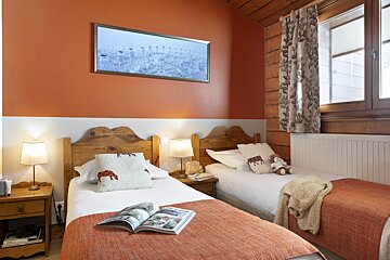 A bedroom with two beds and a picture on the wall