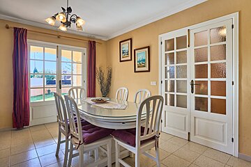 A dining room with a glass table and chairs