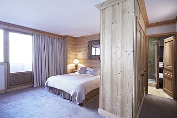 A bedroom with a bed and a mirror on the wall