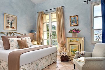 A bedroom with a large bed and a chair