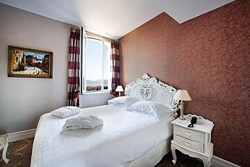 A bedroom with a bed and a painting on the wall