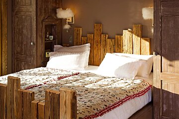 A bed with a wooden headboard and a floral blanket