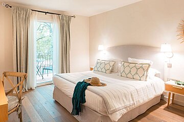 A bedroom with a large bed and a hat on it