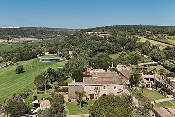 An aerial view of a house and a golf course