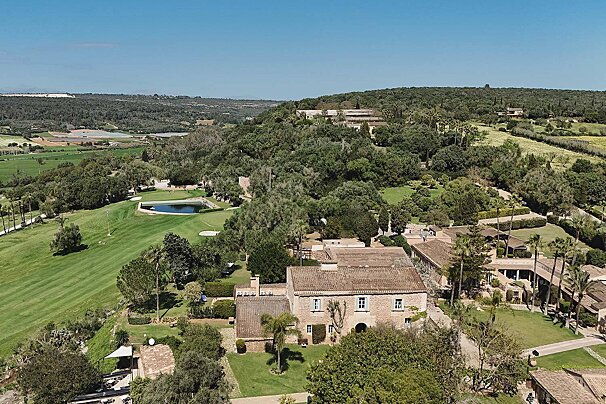 An aerial view of a house and a golf course