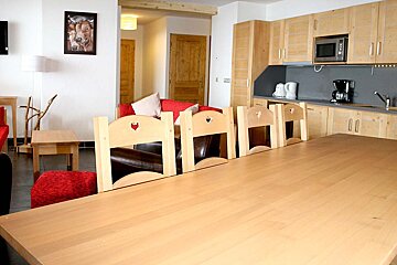 A kitchen with a table and chairs and a picture of a cow on the wall