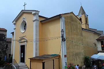 a yellow church with a cross on the tower