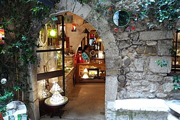 a stone arch way leading into a shop
