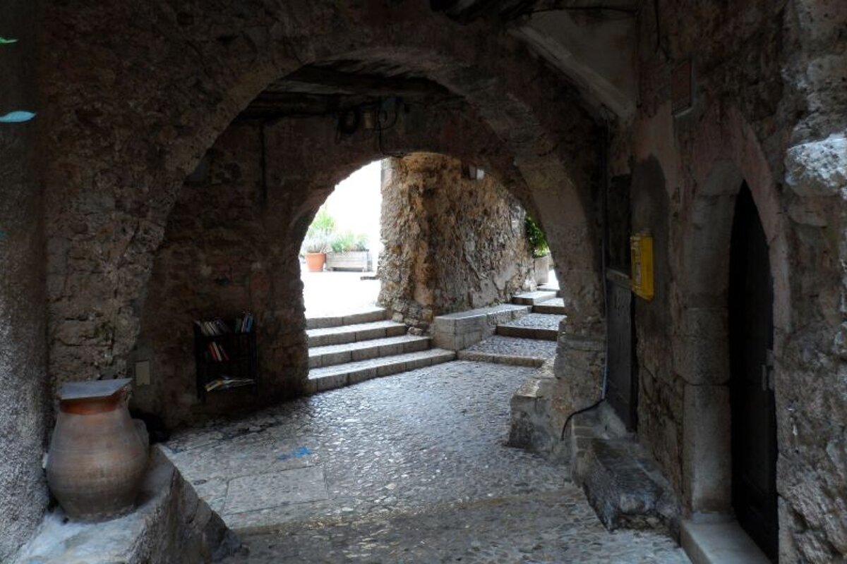 a vaulted arch over a cobbled stone street
