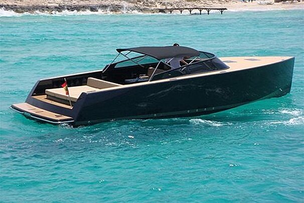 A boat is floating in the ocean near a beach