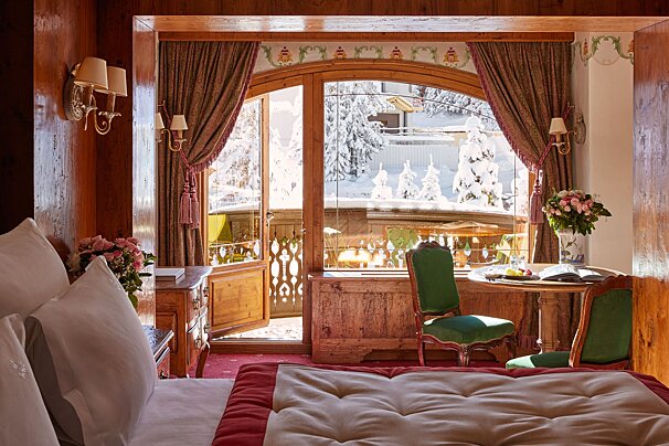 A bedroom with a large bed and a table with a book on it