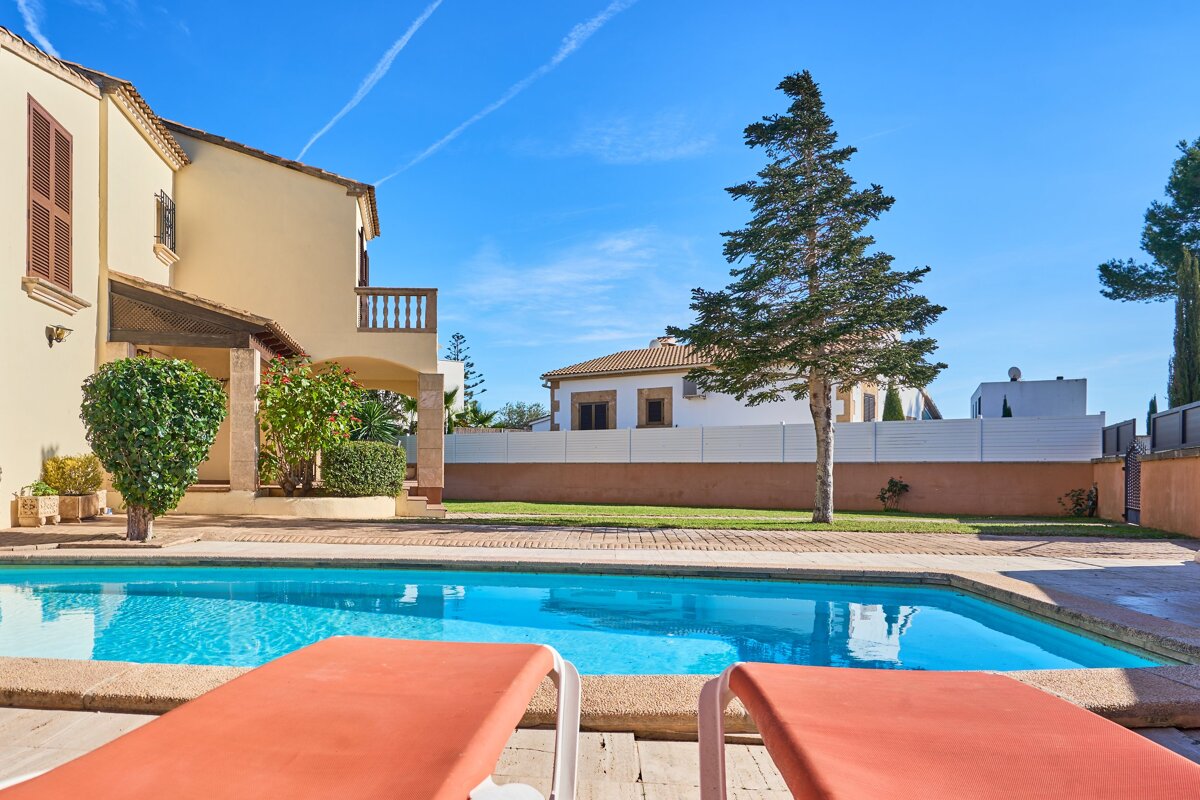 A large house with a swimming pool in front of it