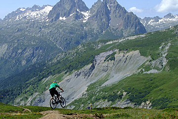 a man on a mountain bike flying over a hip