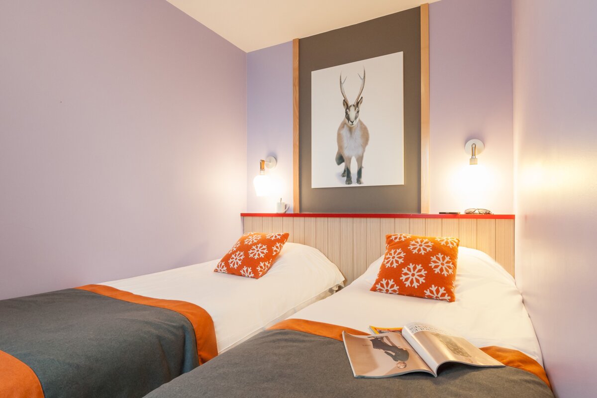 A bedroom with two beds and a picture of a deer on the wall