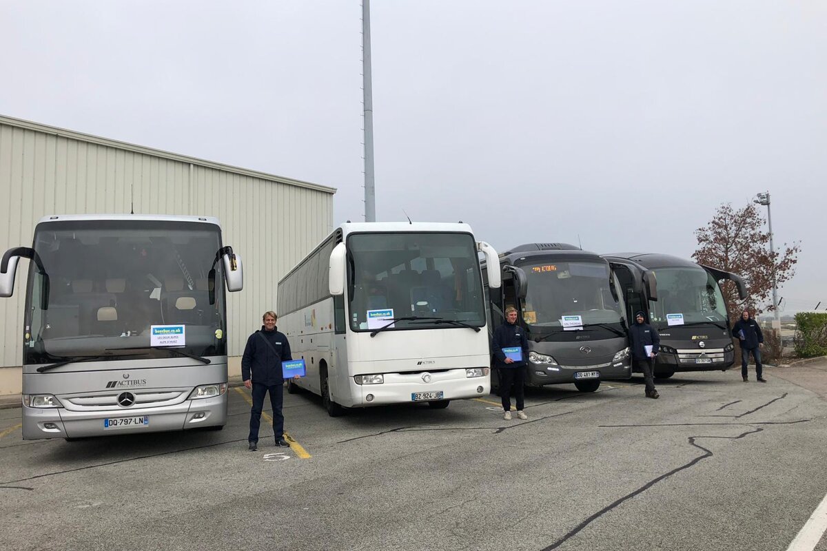 A group of mercedes buses are parked in a parking lot