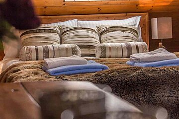 A bed with a lot of pillows and towels on it