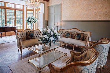 A living room with a couch and chairs and a glass coffee table