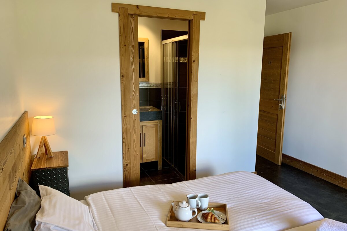 A bedroom with a tray of food on the bed