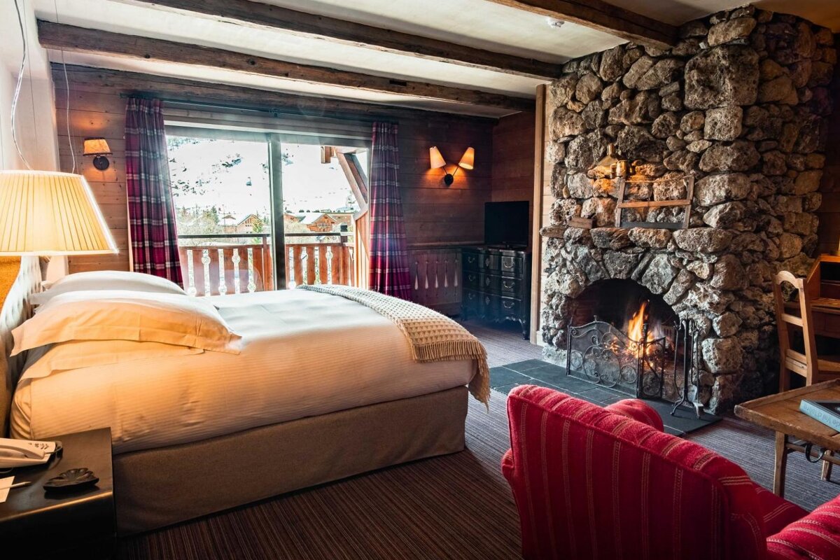 A bedroom with a stone fireplace and a bed