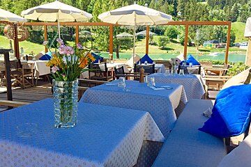 A vase of flowers sits on a table at a restaurant