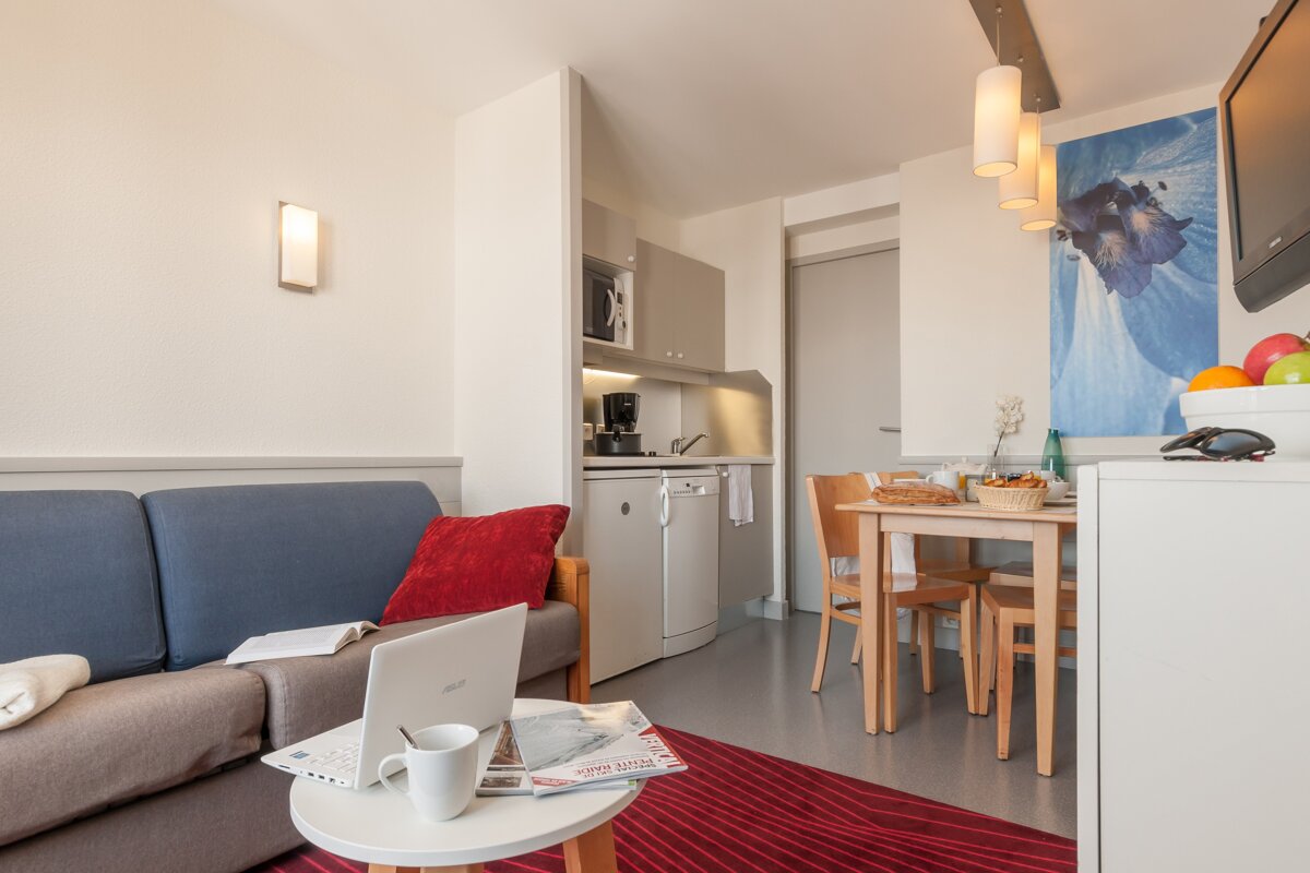 A living room with a couch and a laptop on a table