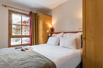 A bedroom with a bed and a book on it