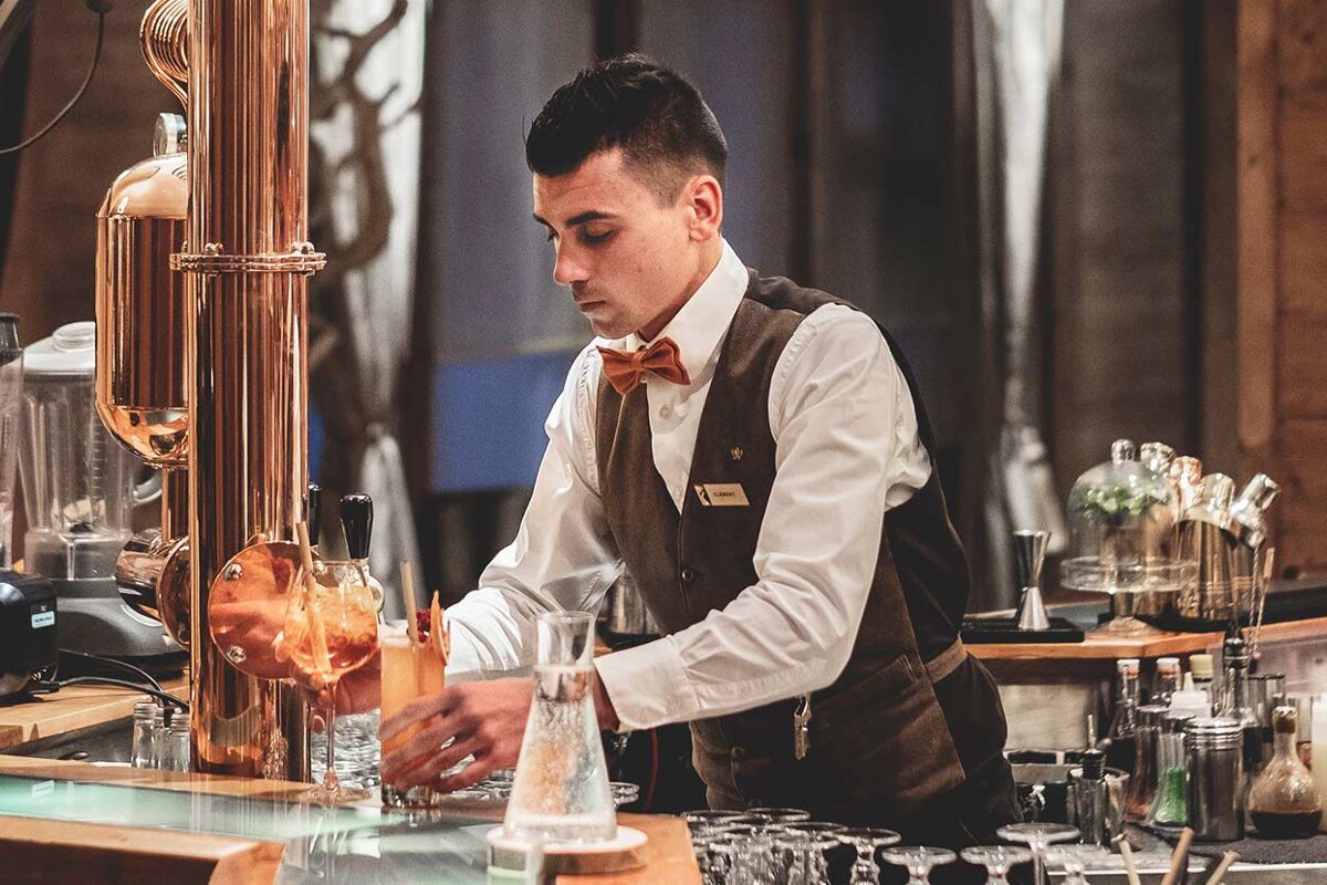 A bartender wearing a name tag that says ' sandro ' on it