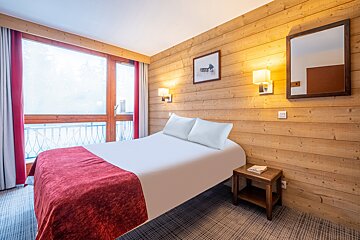A hotel room with a bed and a mirror