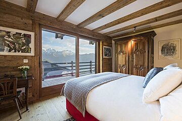 A bedroom with a large bed and a view of the mountains