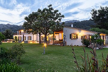 A large white house with a lush green lawn in front of it