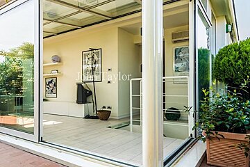 A sliding glass door opens to a living room with a sign that says john taylor