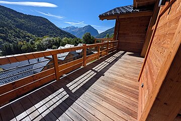 A wooden balcony with a view of the mountains