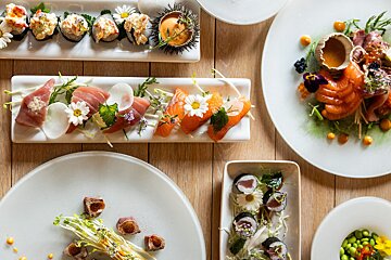 A variety of plates of food on a wooden table