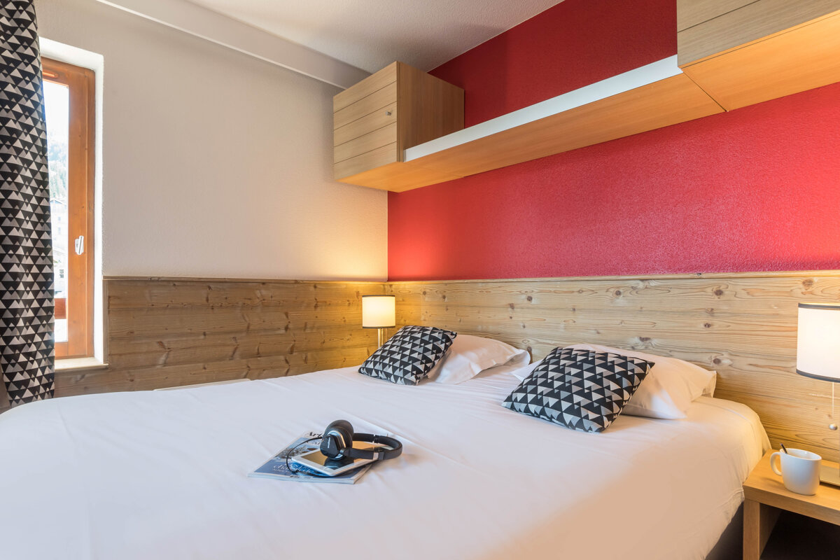 A bed with headphones and a magazine on it