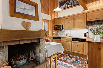 A kitchen with a fireplace and a painting on the wall above it