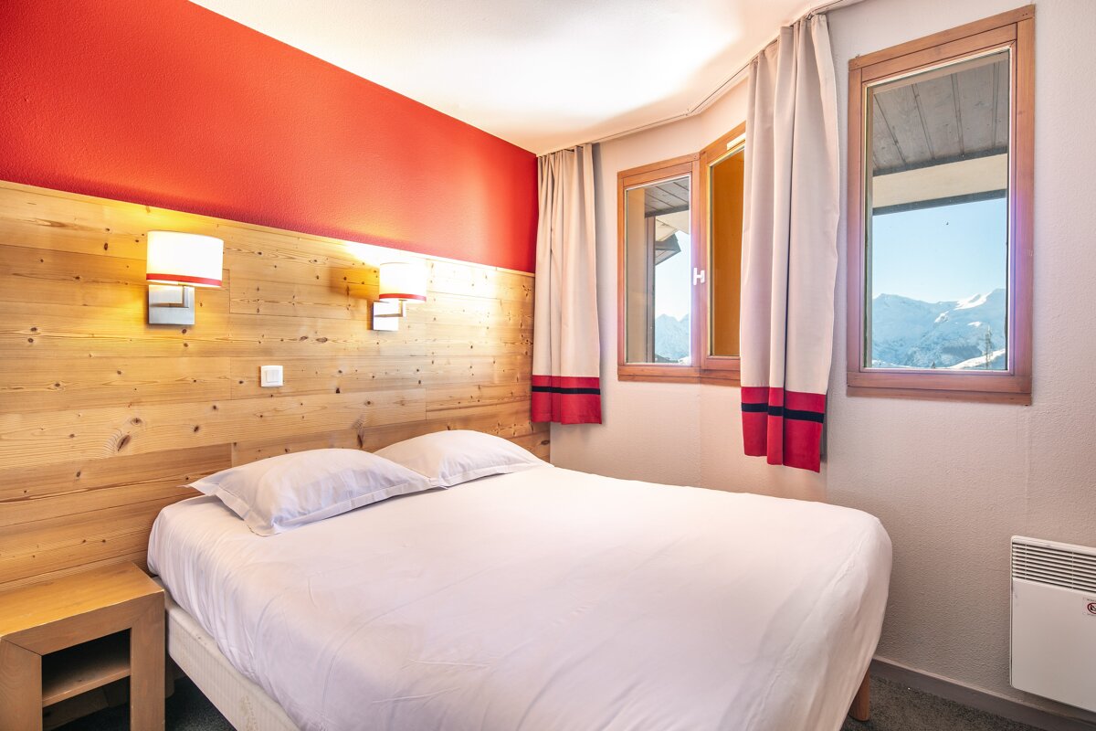 A hotel room with a bed and a window