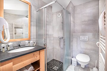 A bathroom with a toilet a sink and a mirror