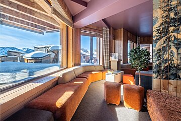 A room with a lot of windows and a view of snowy mountains