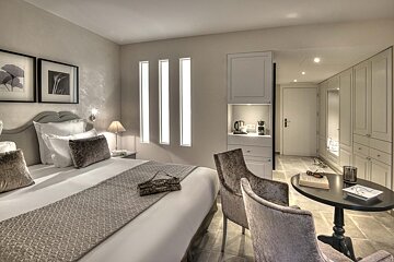 A hotel room with a bed a chair and a table