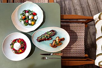 Three plates of food are on a green table