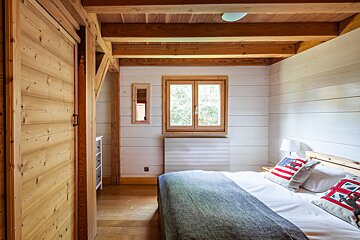 A bedroom with a large bed and a window