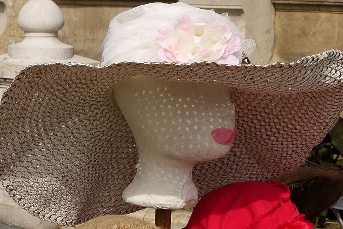 a hat on a model at a market stall