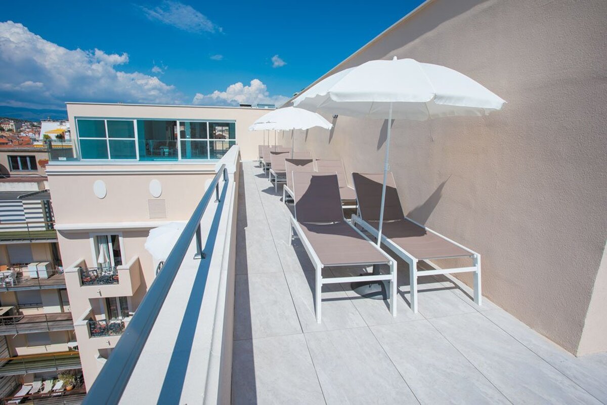 A balcony with chairs and umbrellas on a sunny day