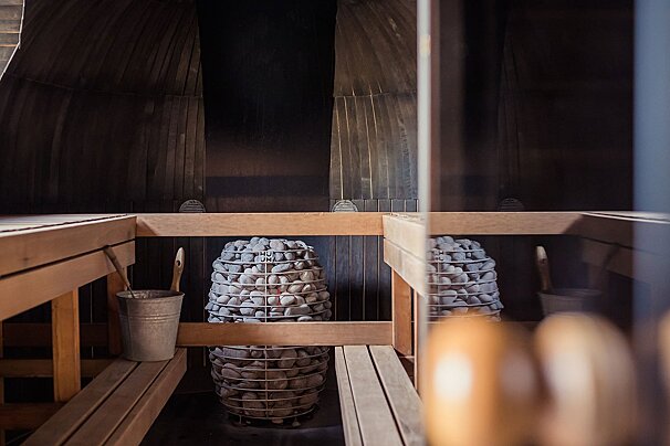 A bucket sits on a wooden bench in a sauna