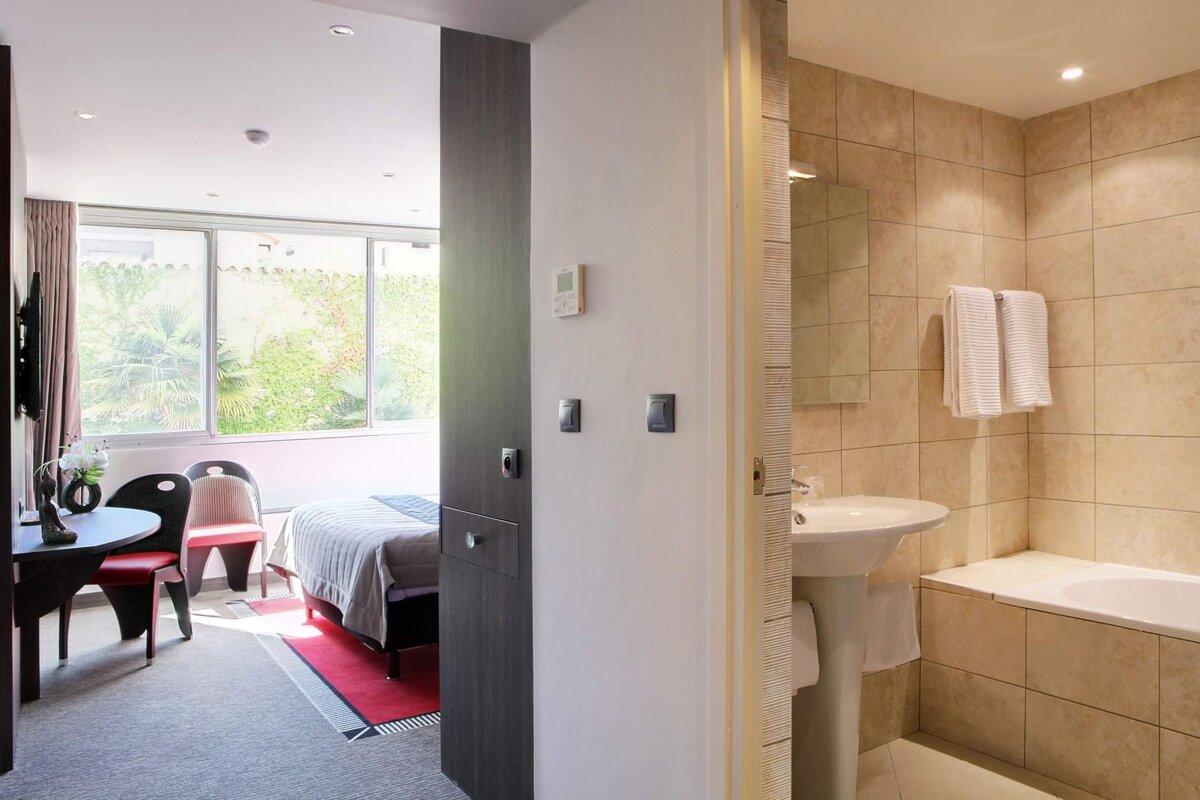 A hotel room with a sink and a window